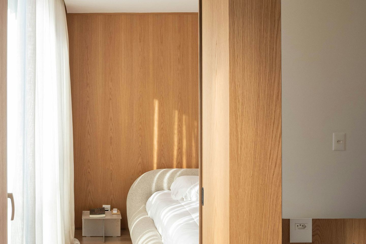 A wooden doorway opening onto a quiet bedroom.