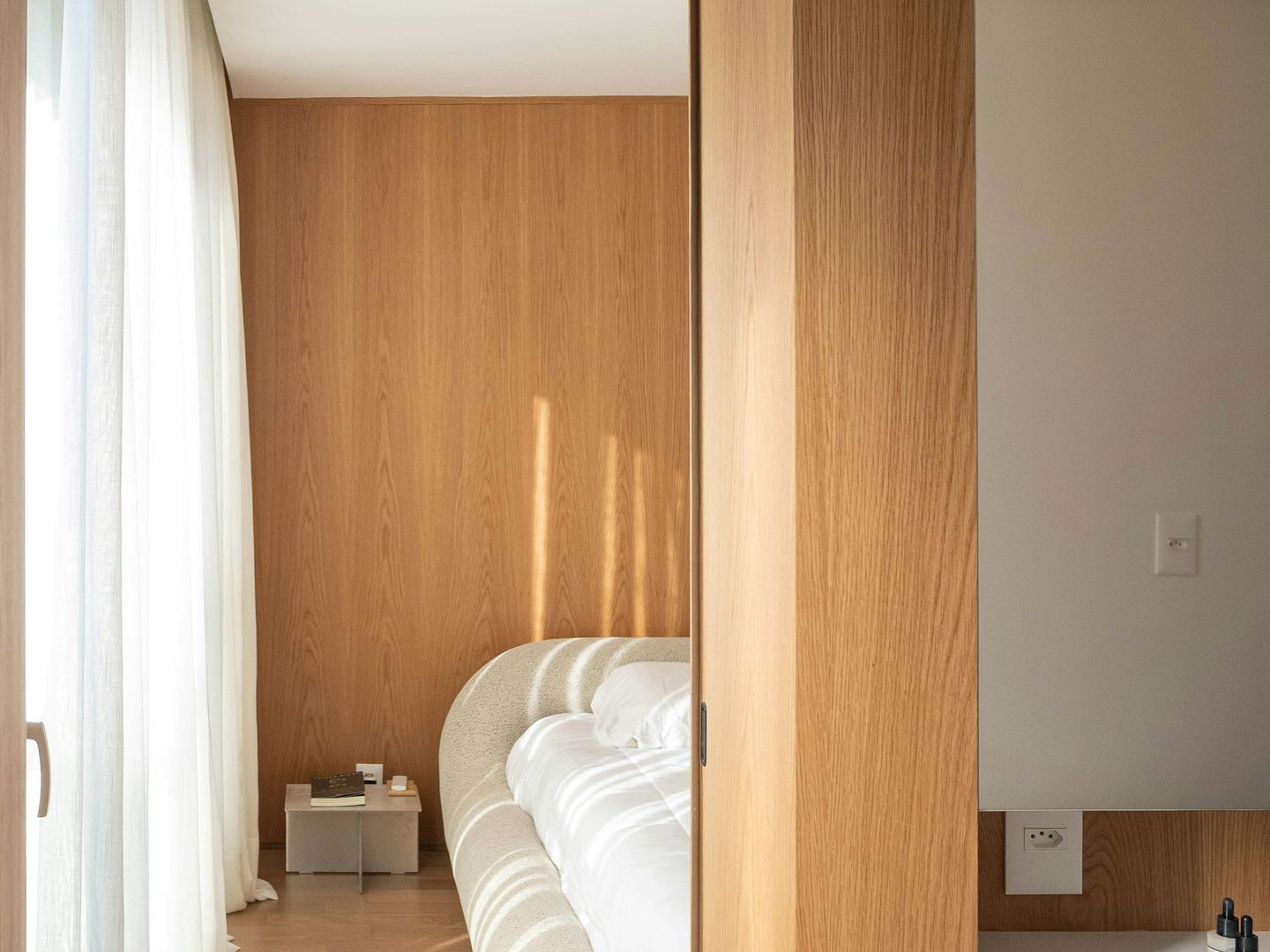 A wooden doorway opening onto a quiet bedroom.