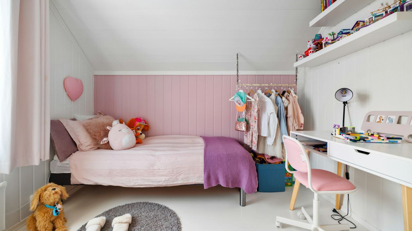 A child’s bedroom with a bed, a desk and a chair.
