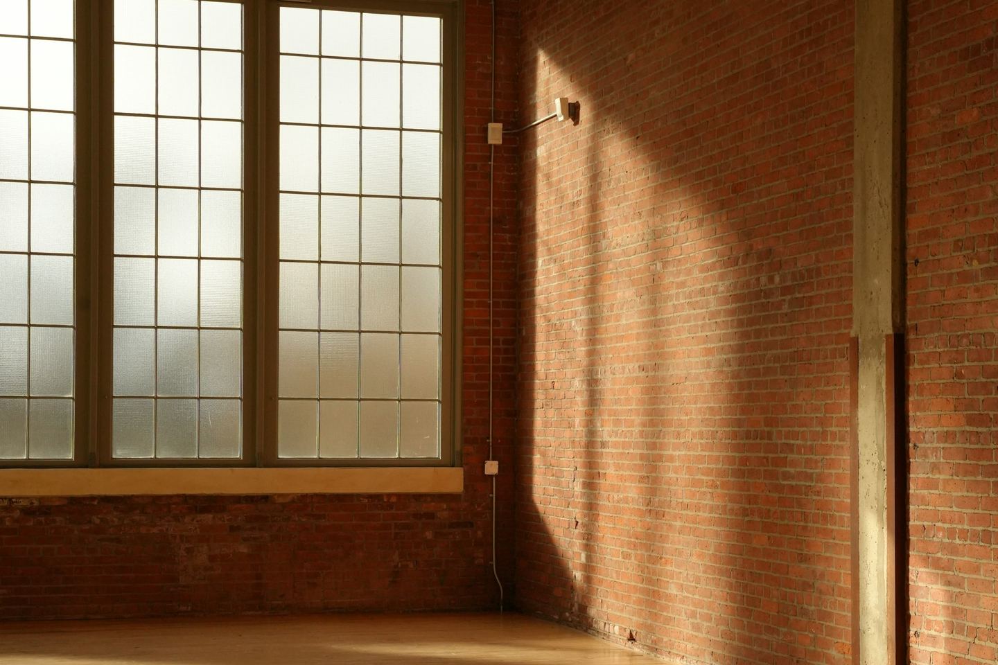Sunlight through a large window laid across a wooden floor.