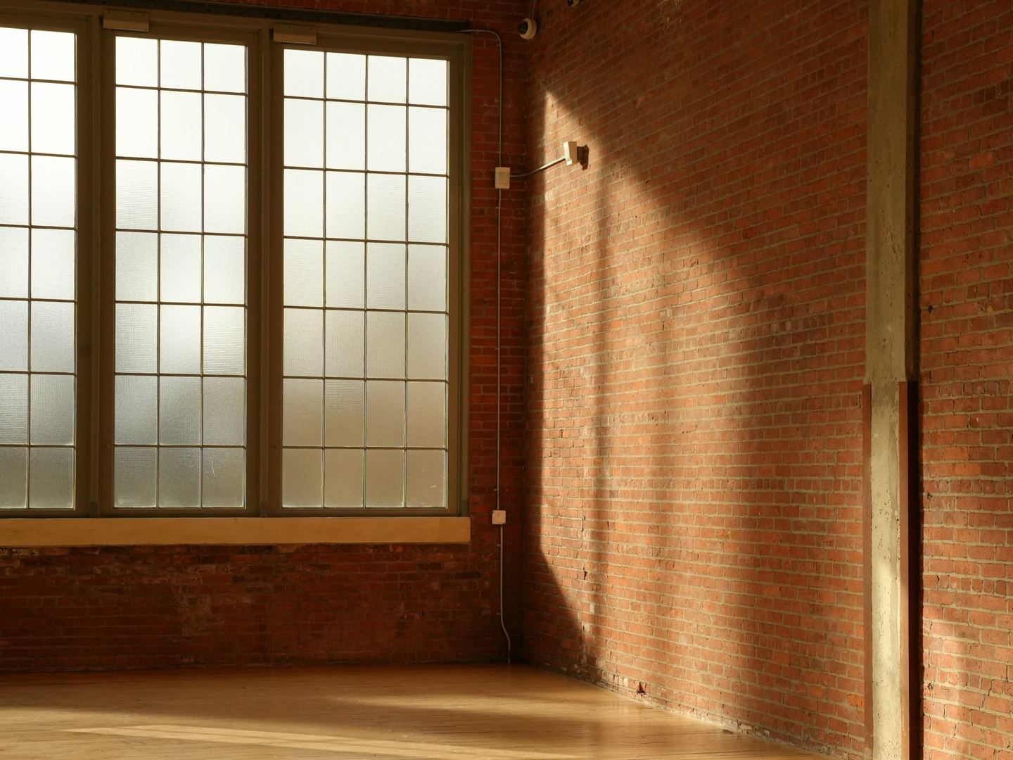 Sunlight through a large window laid across a wooden floor.