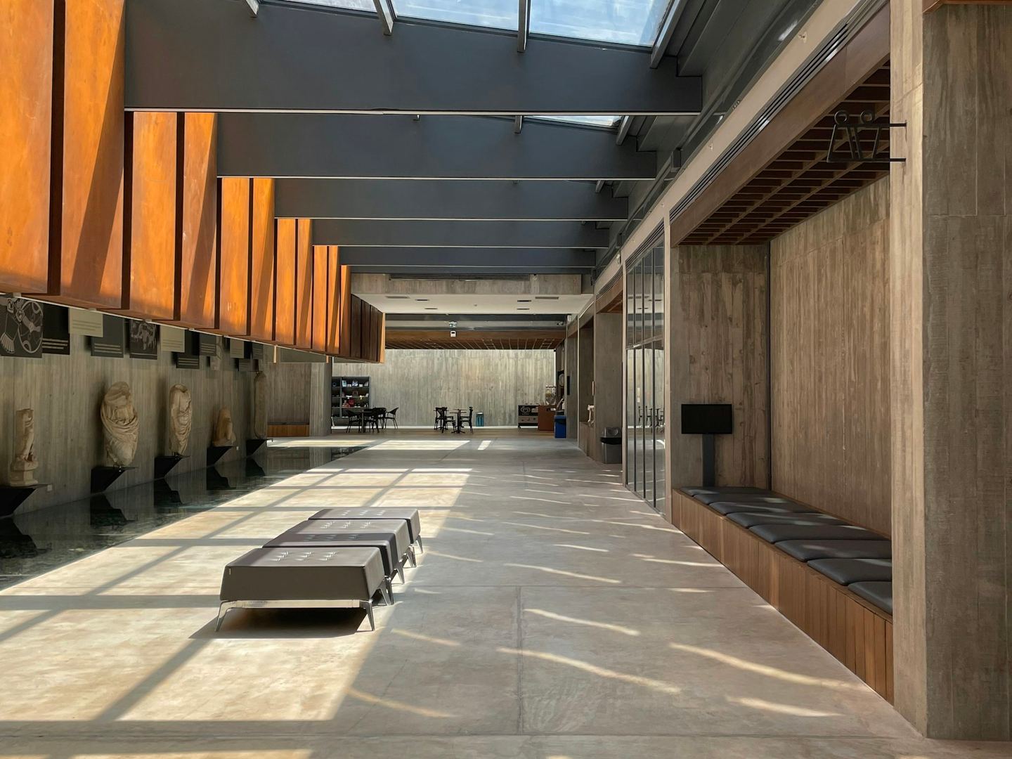 A long hallway with benches under a strip of skylight.