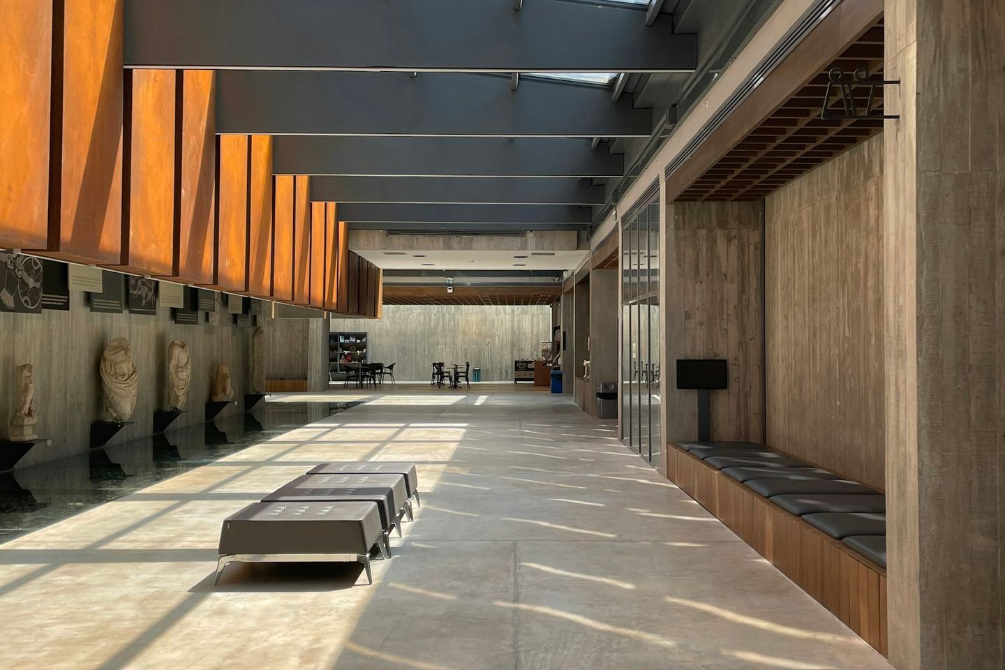 A long hallway with benches under a strip of skylight.