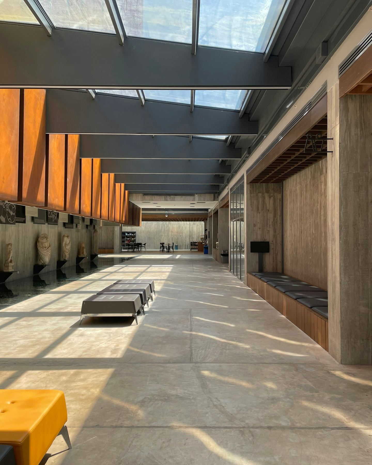 A long hallway with benches under a strip of skylight.