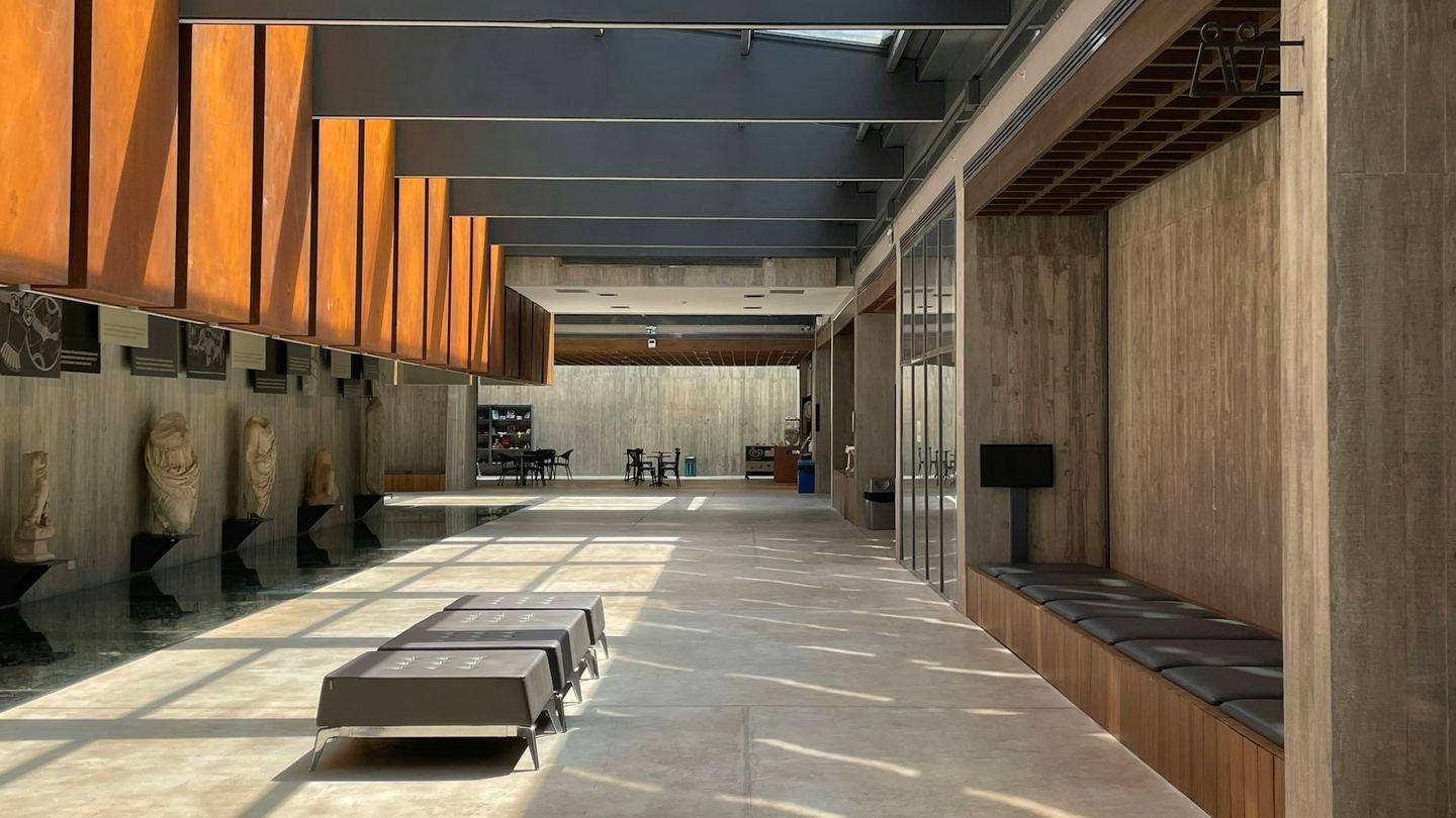 A long hallway with benches under a strip of skylight.