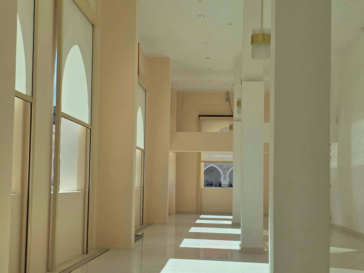Sunlight streams into a modern, empty hallway.