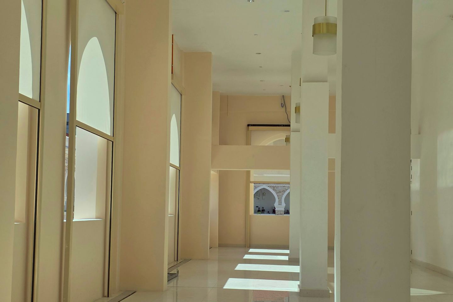 Sunlight streams into a modern, empty hallway.