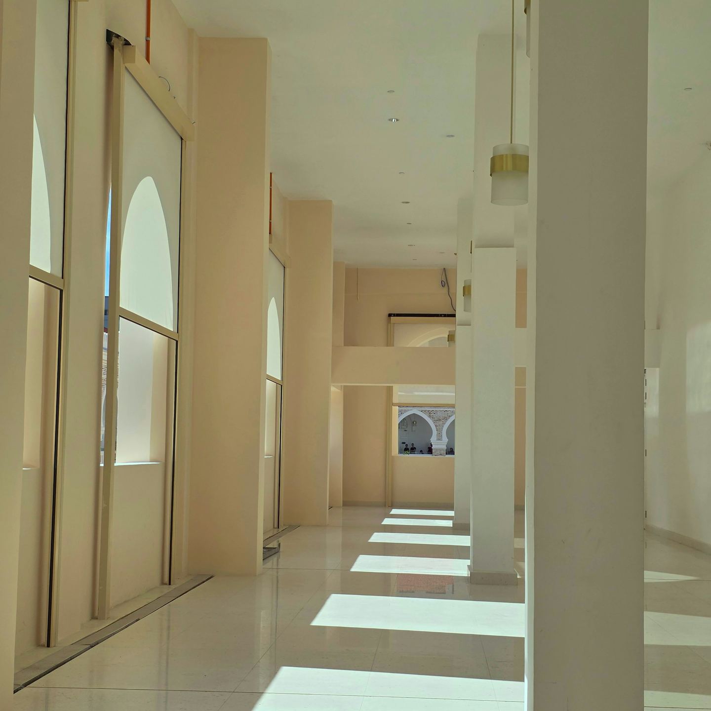 Sunlight streams into a modern, empty hallway.
