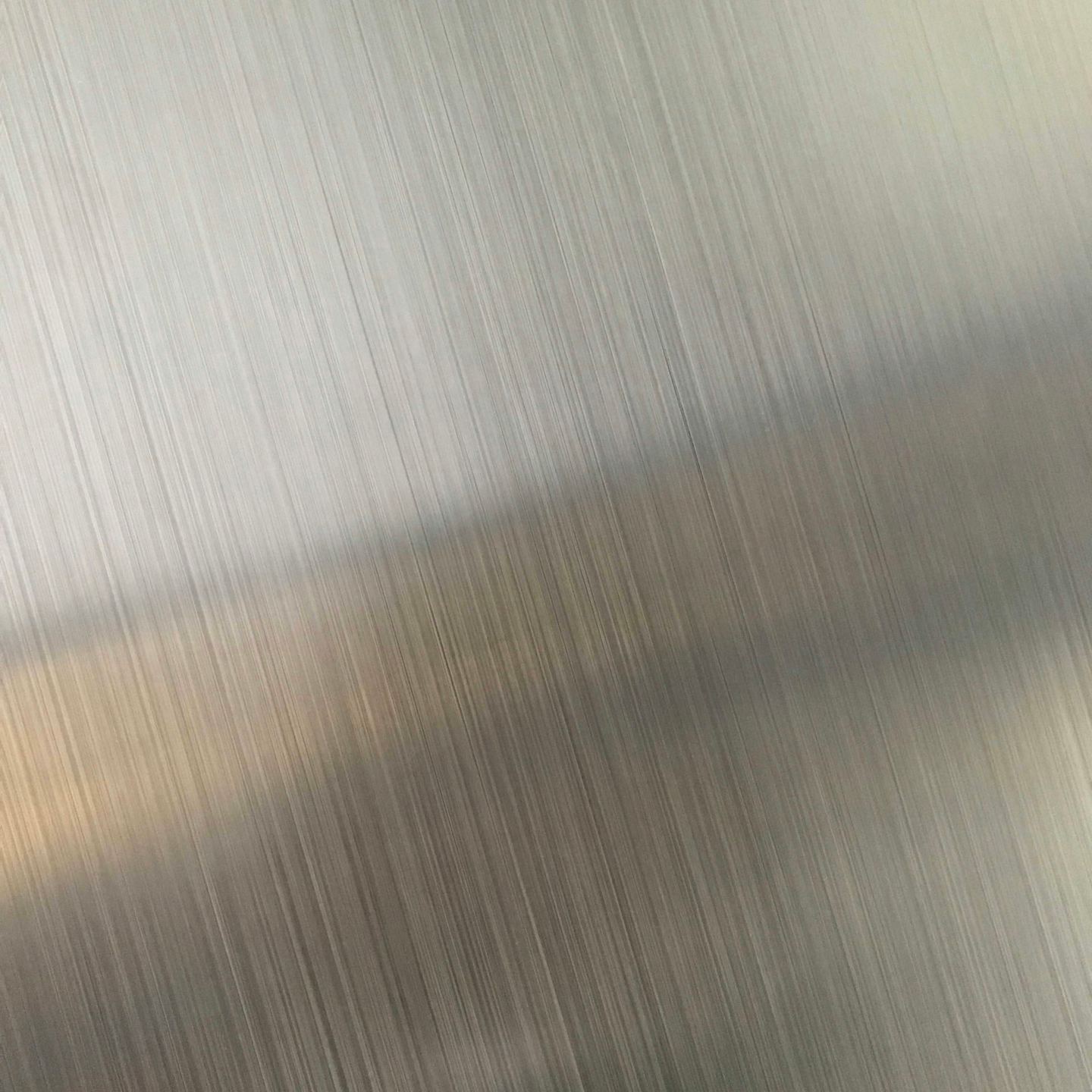 Brushed metal with fine vertical lines and a diagonal reflection.