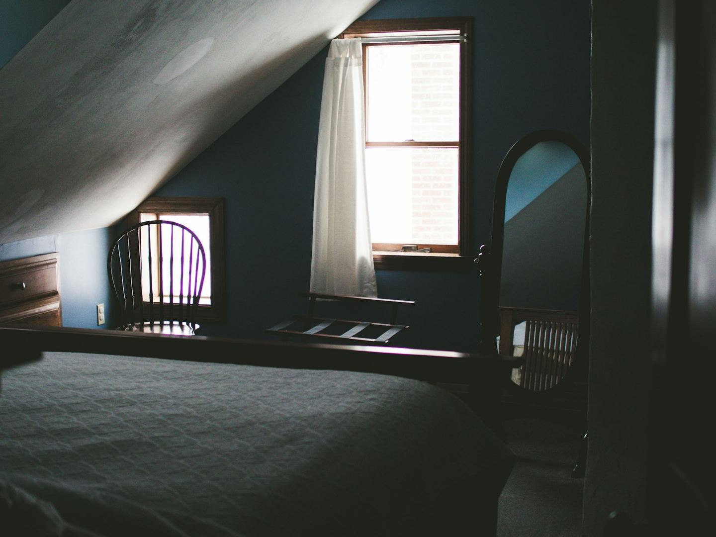 An oval mirror near a window.