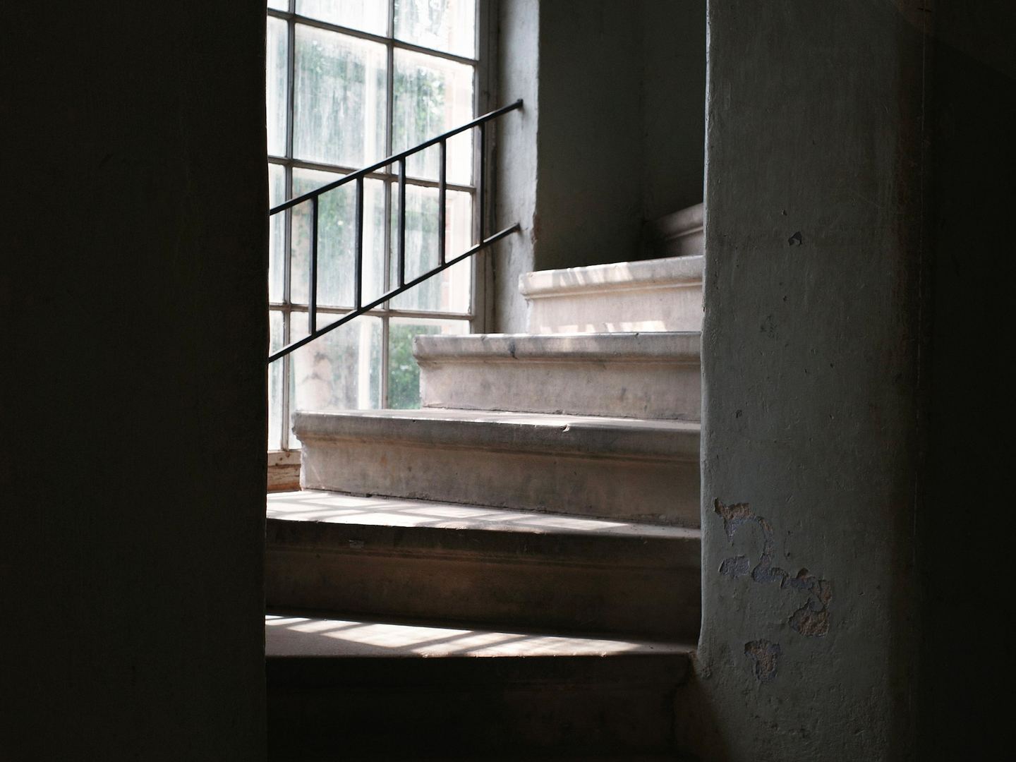Sunlight streams down a concrete staircase.