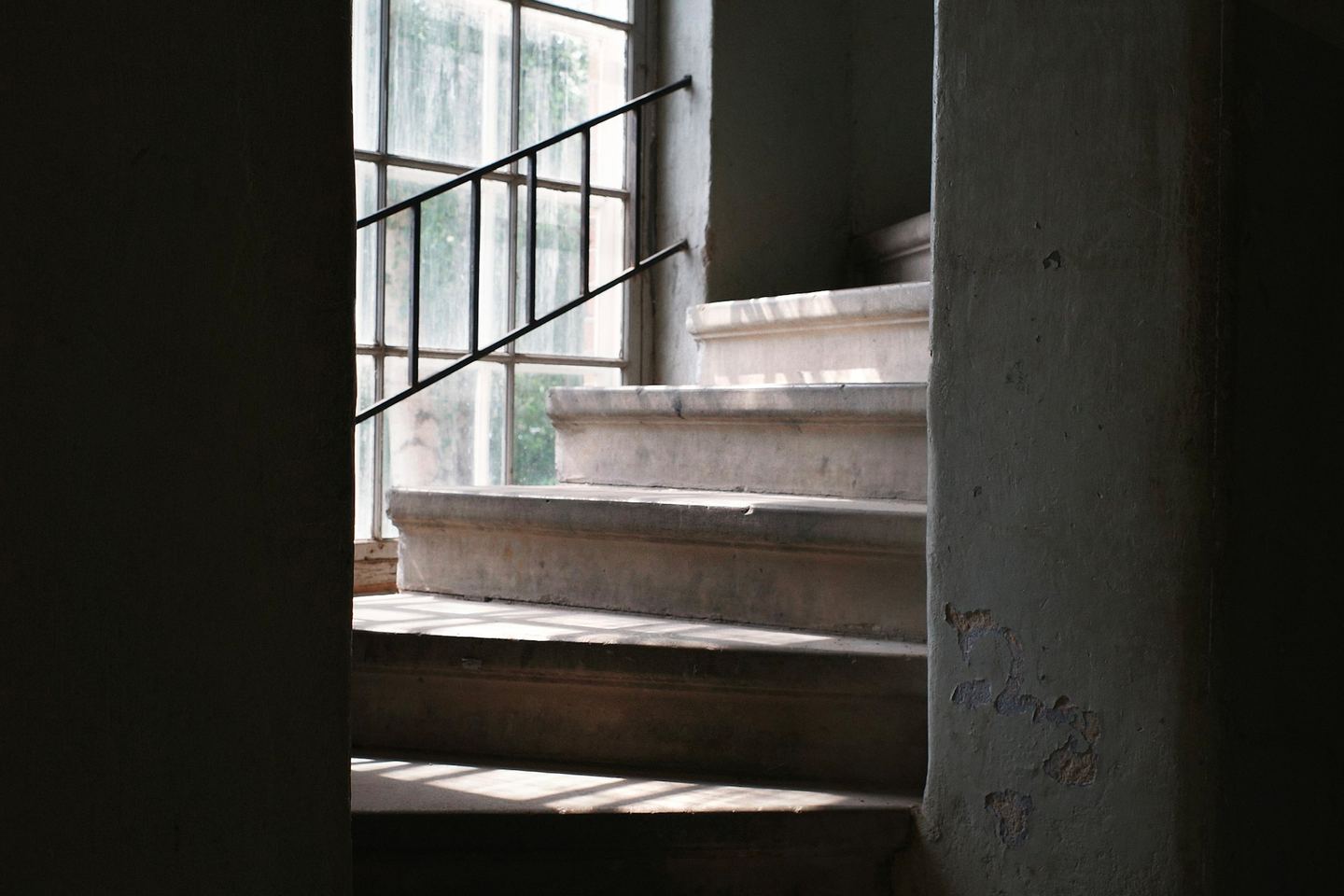 Sunlight streams down a concrete staircase.