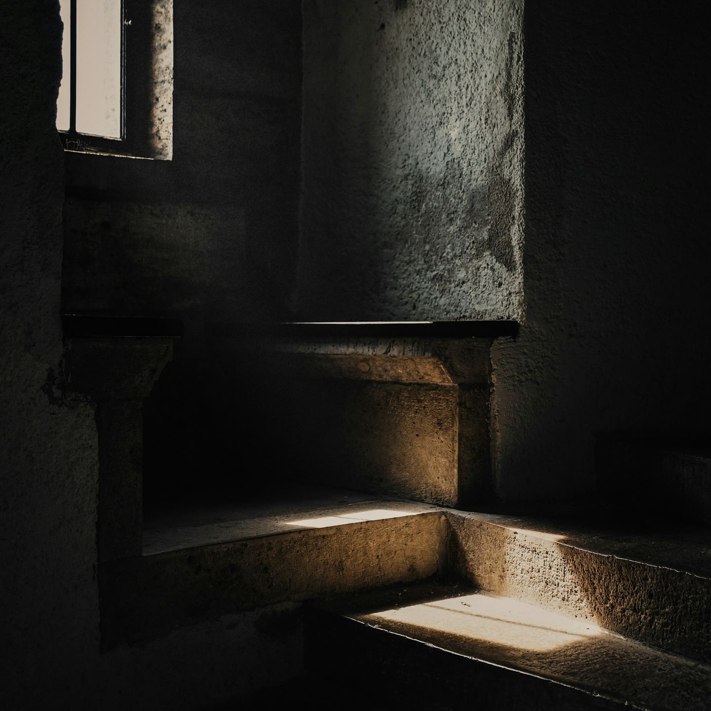 A dark room with stairs and a window.