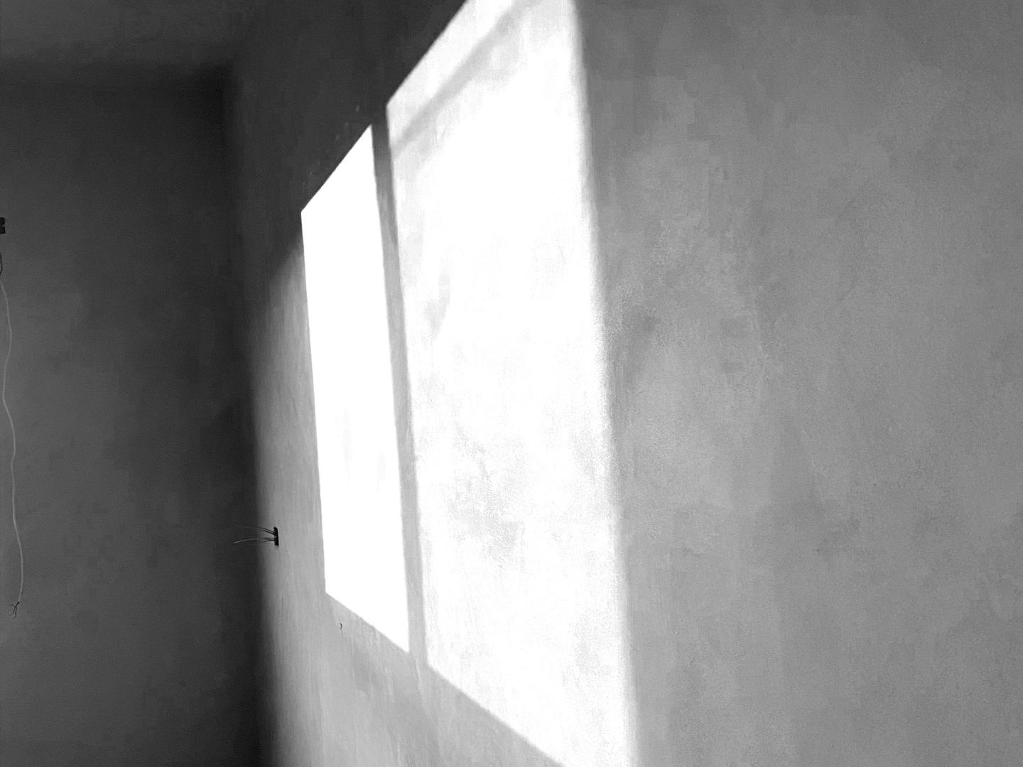 Sunlight streaming through a window onto a plaster wall.