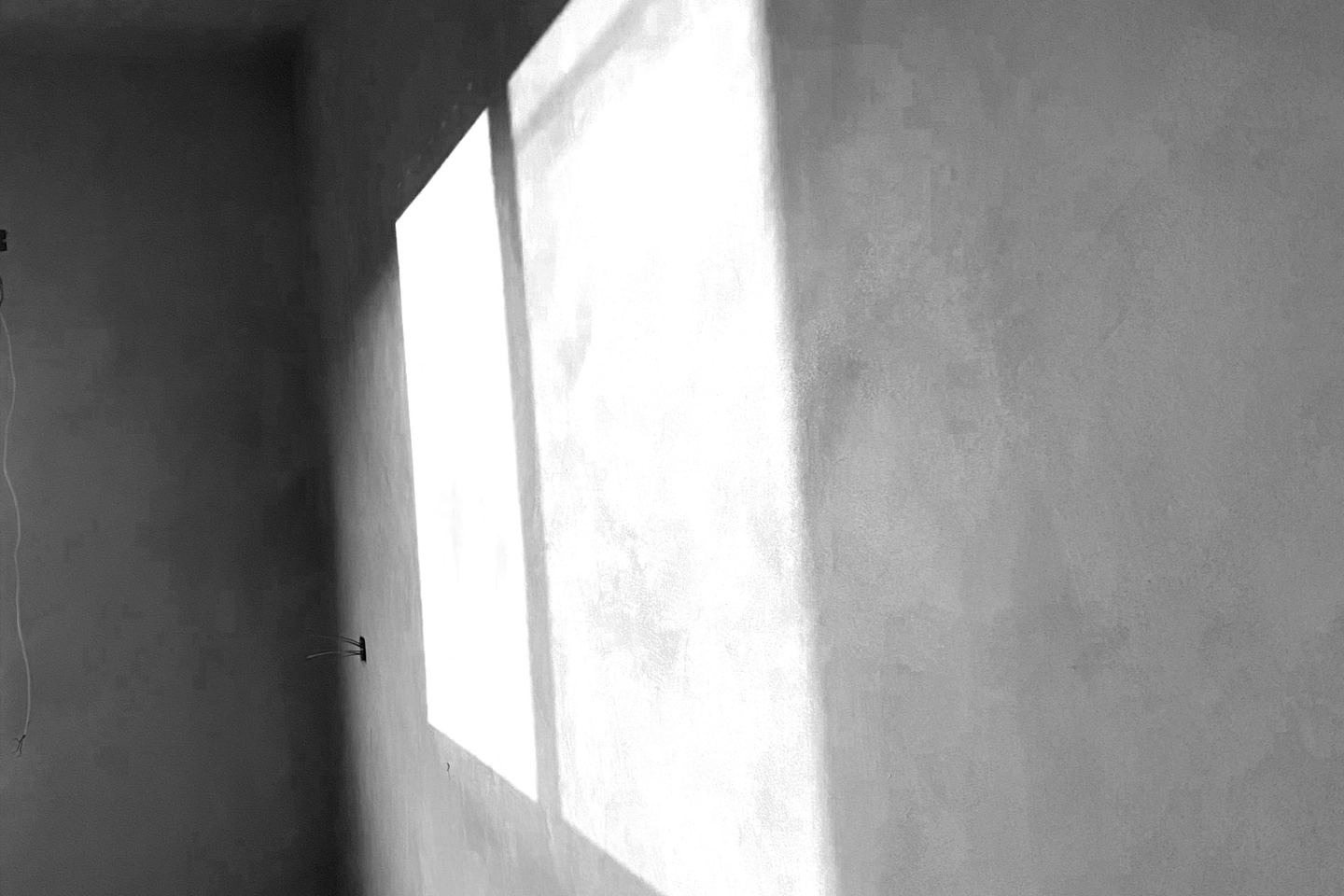 Sunlight streaming through a window onto a plaster wall.