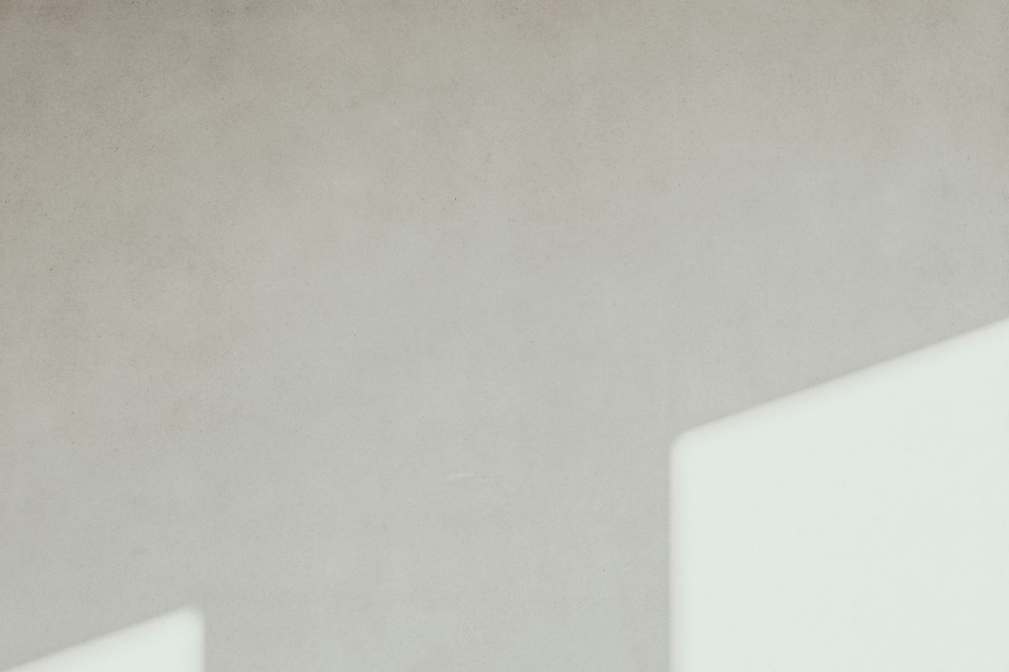 A concrete wall with geometric light and shadow.