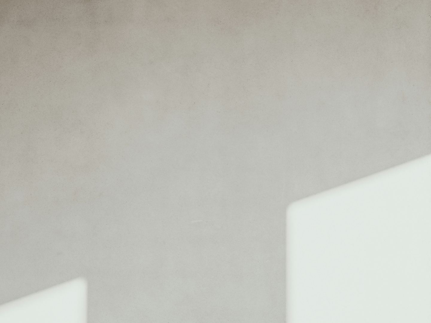 A concrete wall with geometric light and shadow.